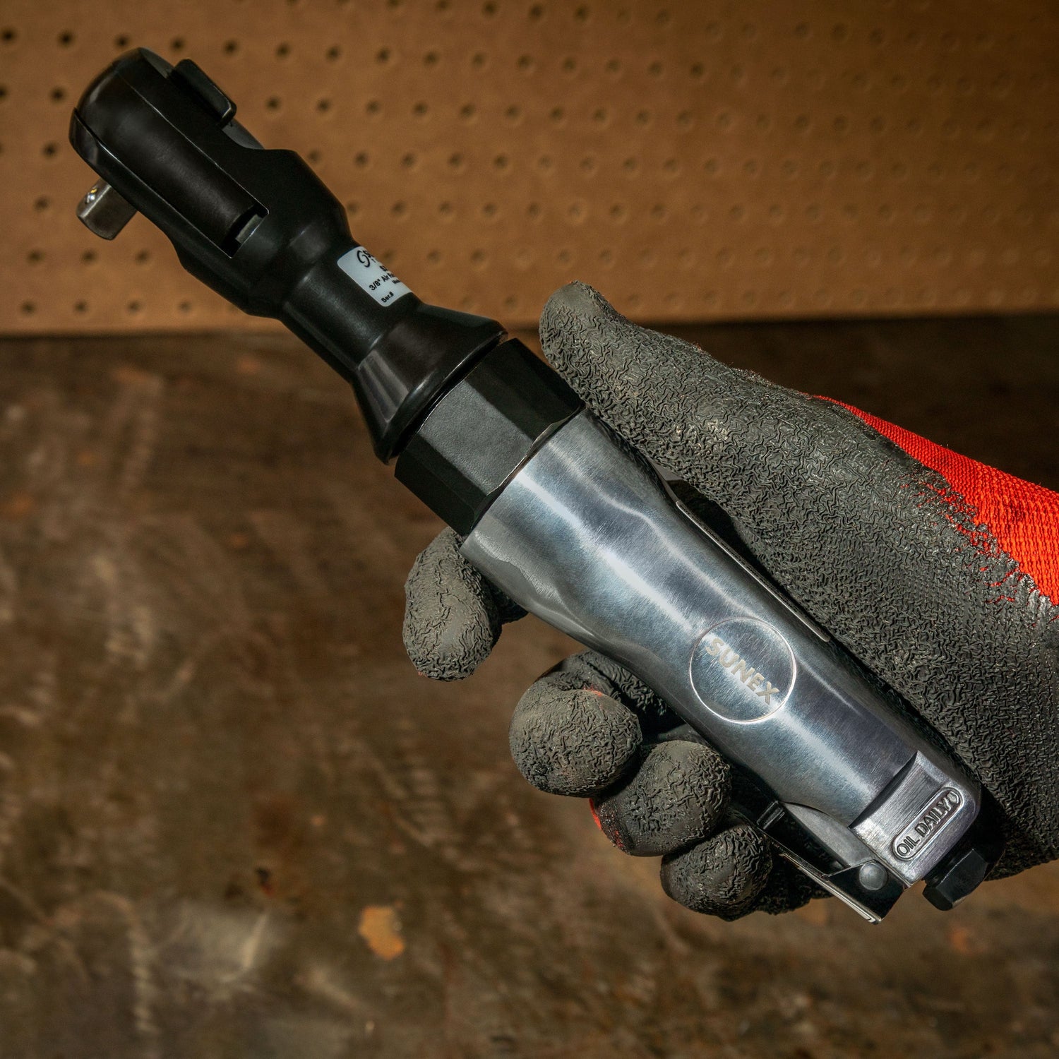 SX113 3/8" Drive Air Ratchet being held by a technician in a workshop environment