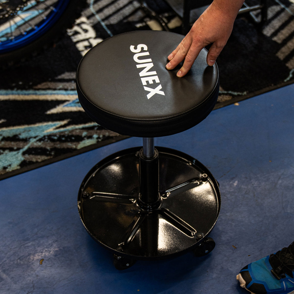 SUNEX Seat being rolled by a technician in a garage environment.