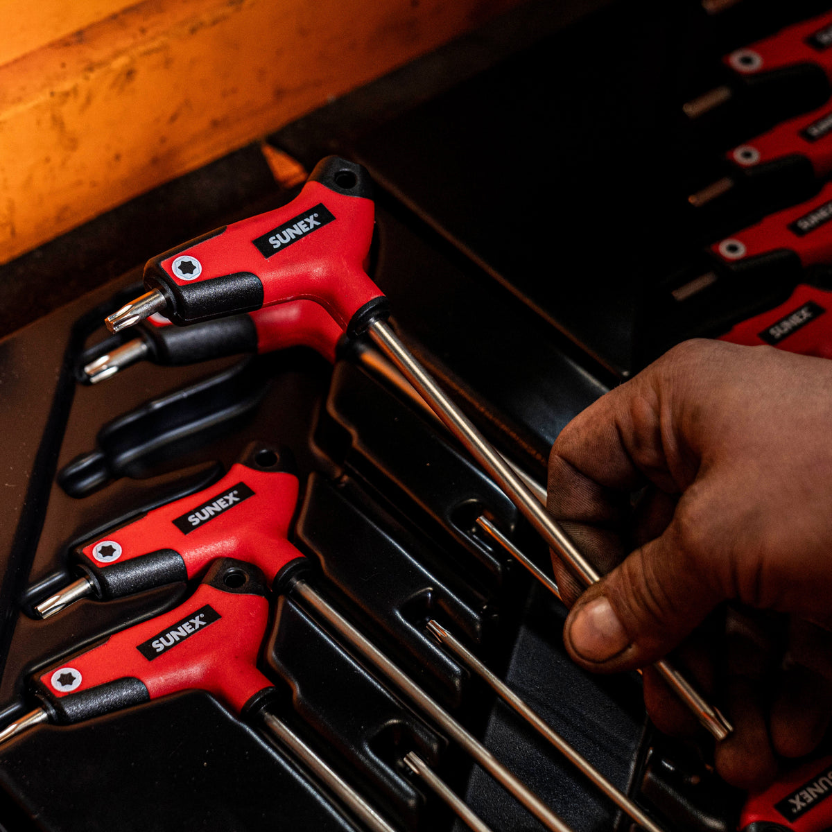 SUNEX Tools T-Handle Keys in organization tray in tool box with one being picked up by a technician.