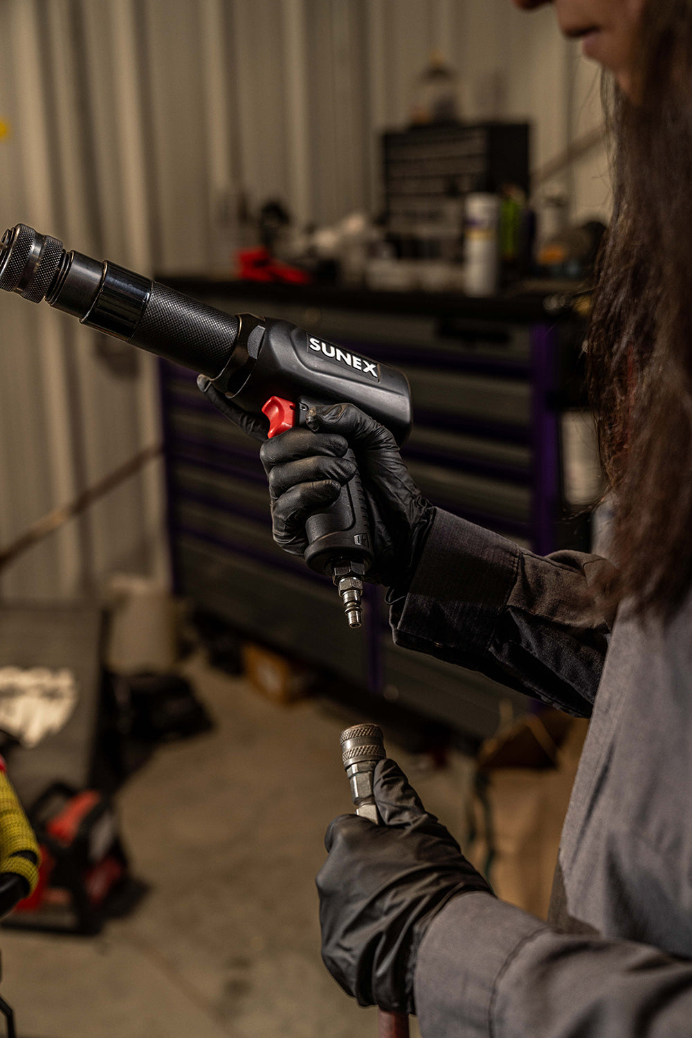 SUNEX SX2302 Heavy-Duty Air Hammer with air hose being attached in body shop