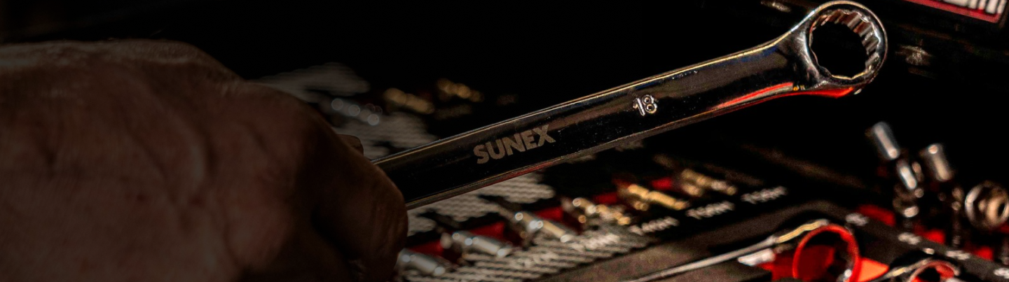 SUNEX Tools 18mm Combination Wrench being held by a technician above a SUNEX Tool Box.